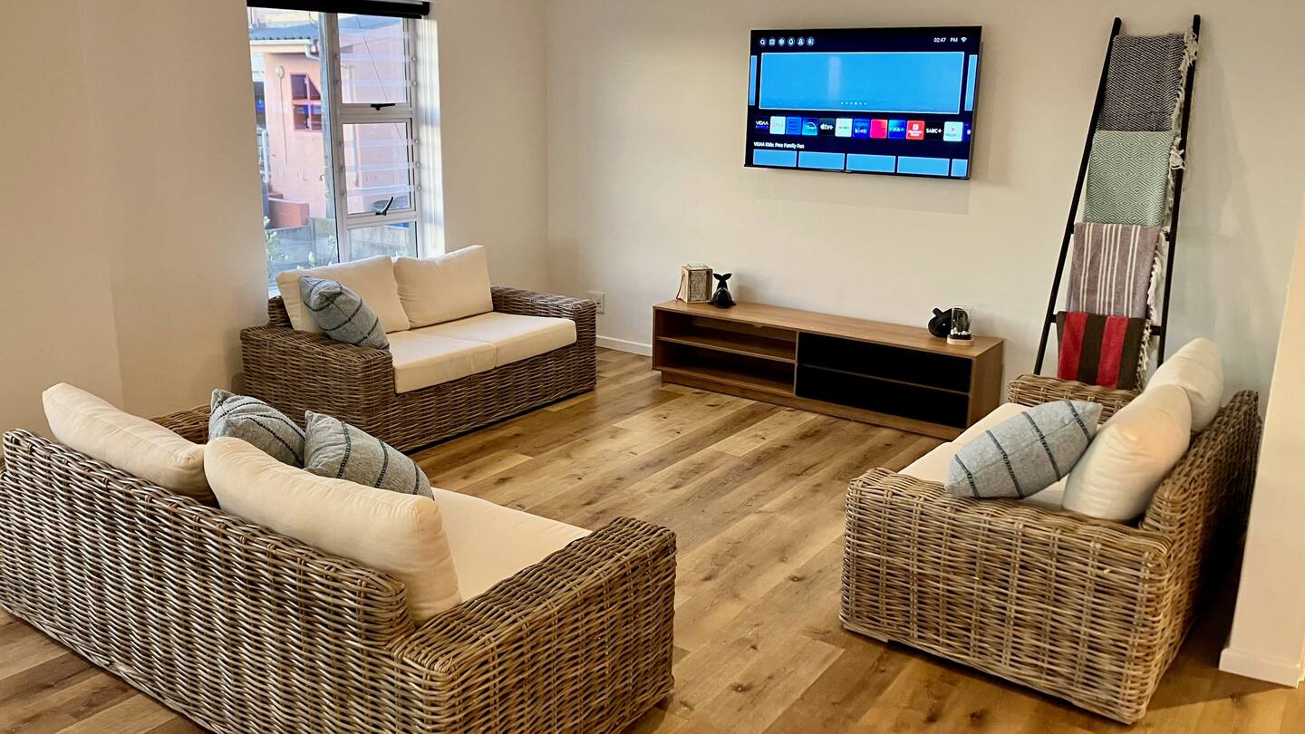 Living room with woven sofas and a wall-mounted TV